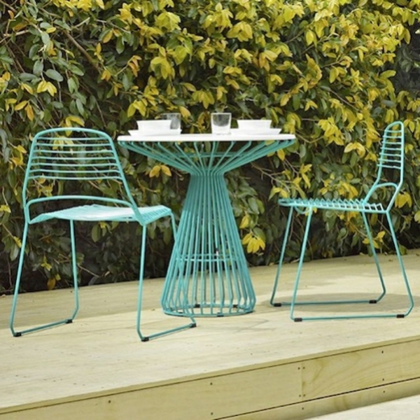 farbige-grüne-Metallstühle-mit-einem-kleinen-Gartentisch