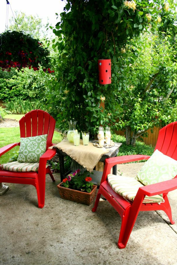 zwei-rote-Stühle-im-Garten-mit-weißen-Sitzkissen