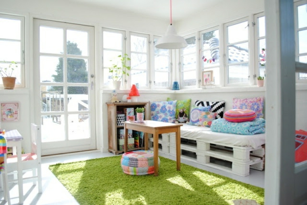 sofa-aus-paletten-im-zimmer-mit-weißer-gestaltung- grüner teppich