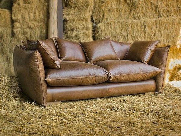 vintage-ledermöbel-sofa-mit-vielen-dekokissen- in braun