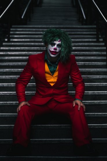 horror kostüm joker in rotem anzug grüne haare am treppen
