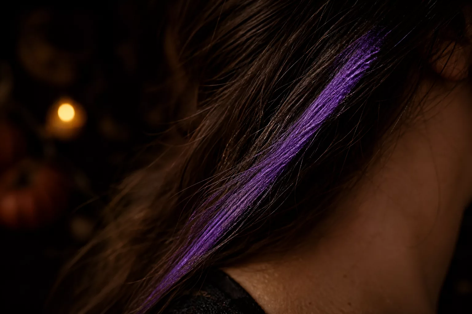 Auswaschbare Haarkreide in Lila auf dunklem Haar aufgetragen