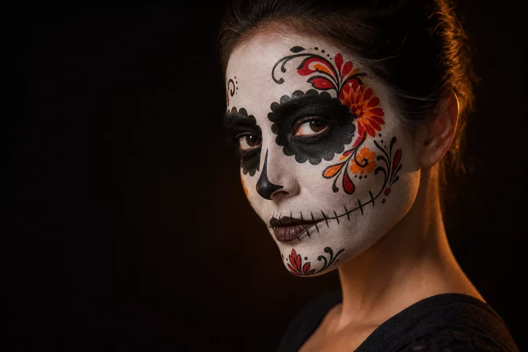 Halloween Gesicht als Sugar Skull geschminkt mit weißer Basis und Blütenmuster