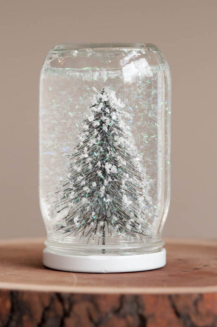 Selbstgemachte Schneekugel, Tannenbaum Figur und künstlicher Schnee in Einmachglas 