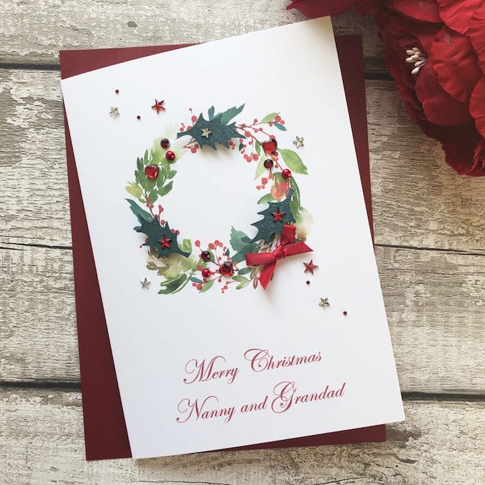 DIY Weihnachtskarte mit Weihnachtskranz, dekoriert mit kleinen Elementen, Perlen und Sterne, kleine rote Schleife 