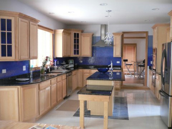schöne küche mit blauen wänden  und hölzernen schränken