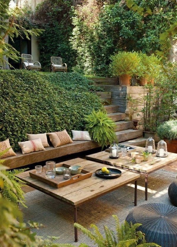 gartenbank-mit-tisch-umgeben-von-büschen- interessant und kreativ gestaltet - sehr schön
