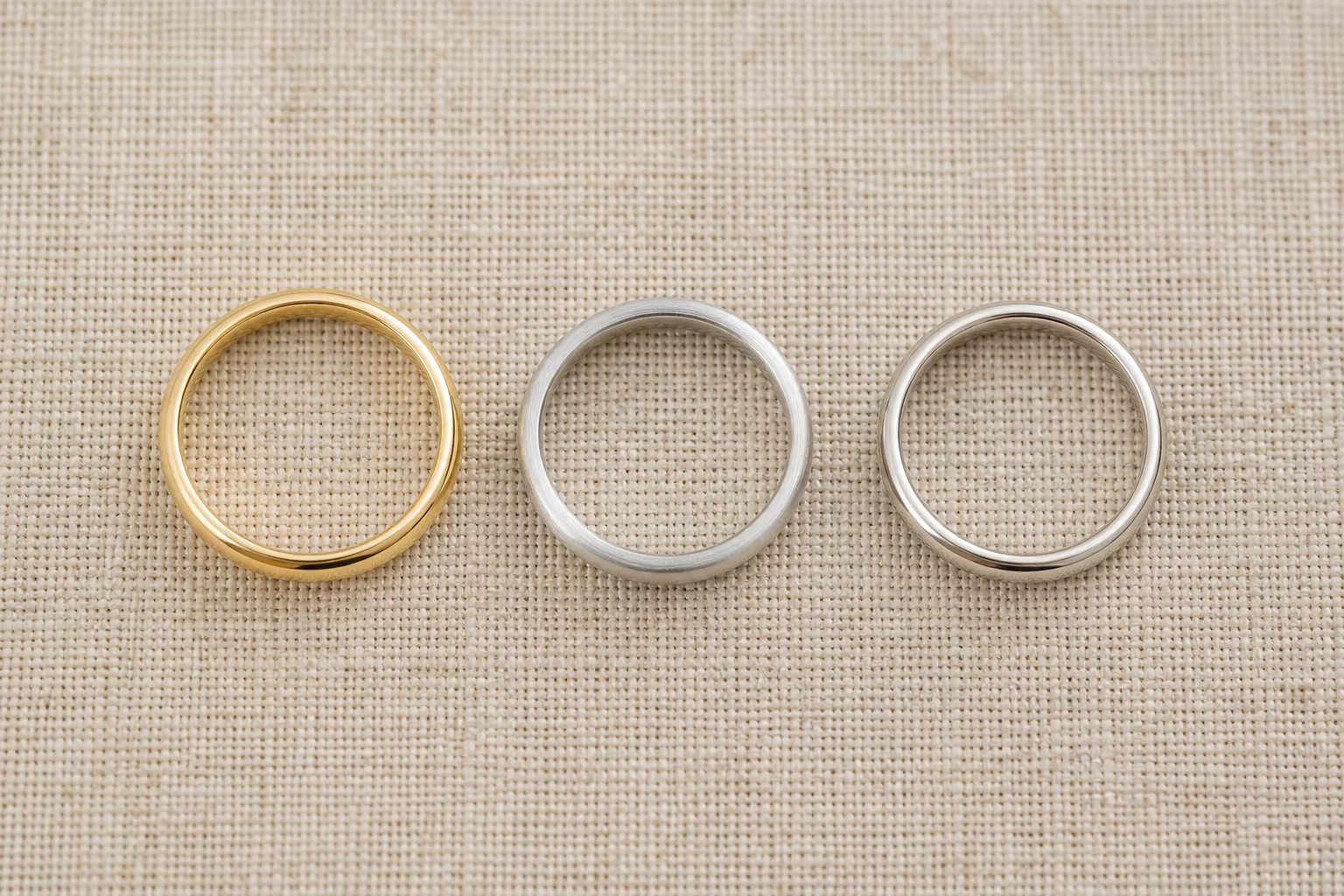 Drei schlichte Ringschienen aus Gelbgold, Weißgold und Platin im Vergleich