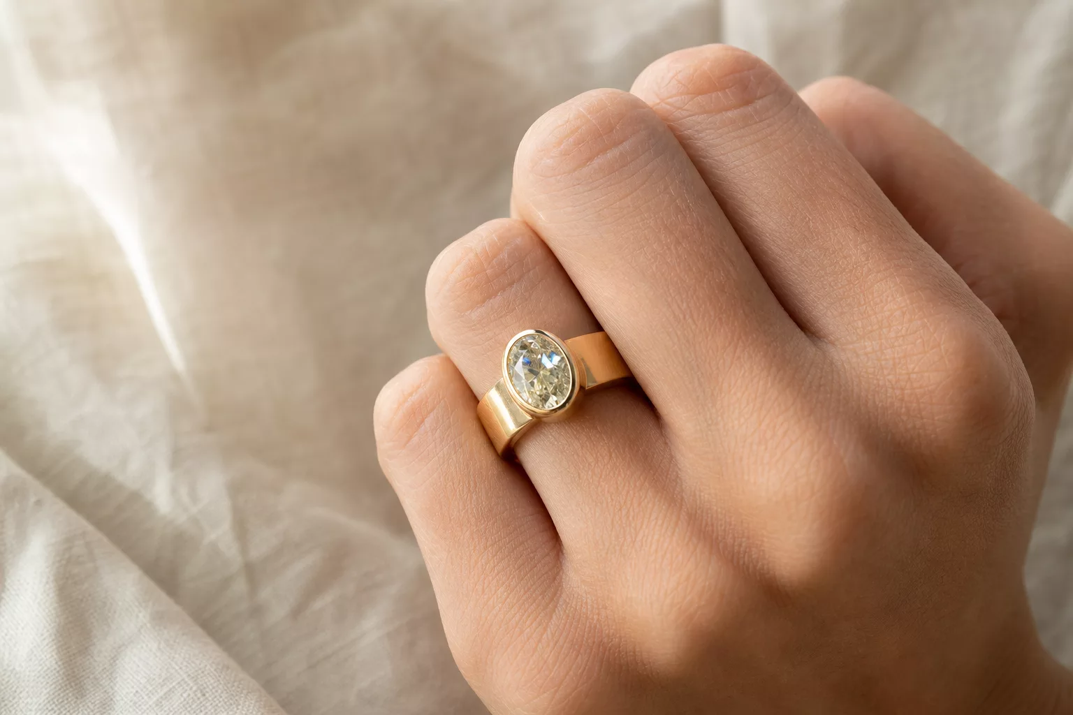 Verlobungsring 2026 mit breitem Goldband und ovalem Stein in Zargenfassung
