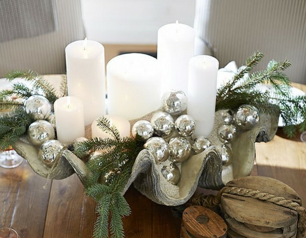 weiße weihnachtsdeko - hölzerner tisch mit schönen weißen kerzen darauf