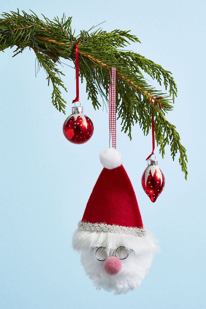 Weihnachtsdeko Ideen, echte Tannenzweige schmücken, rote Christbaumkugeln, Weihnachtsmann aus Watte mit Weihnachtsmütze 