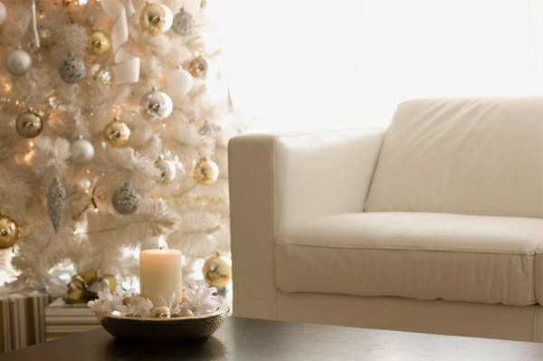 weiße weihnachtsdeko - großer tannenbaum und schickes sofa in weißer farbe