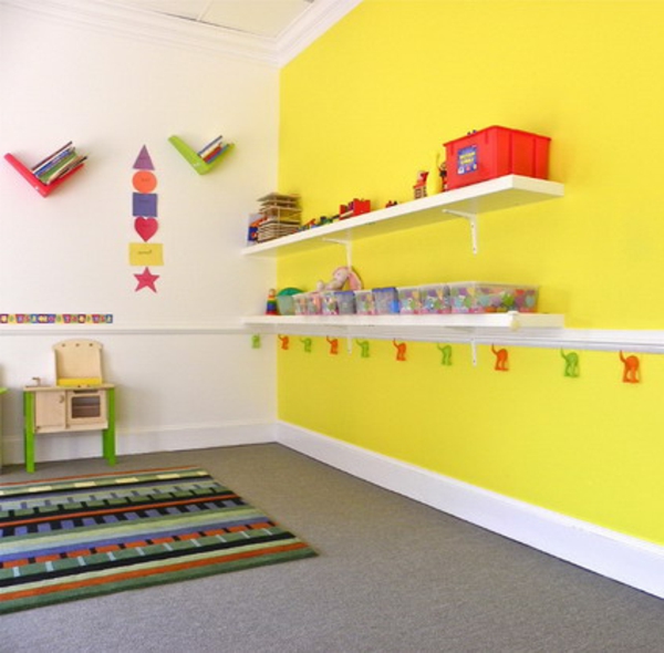 kindergarten-interieur-gelbe-wand-mit-regalen