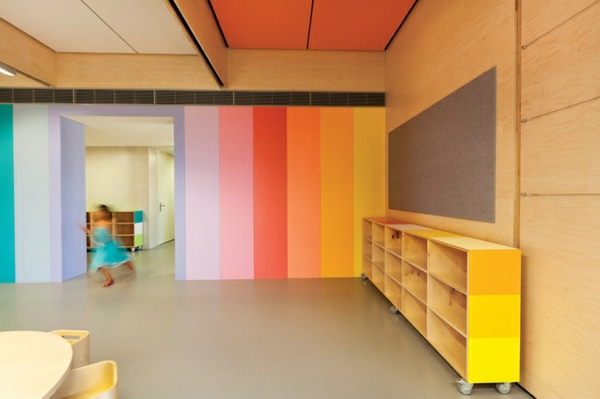 kindergarten-interieur-gelber-schrank-mit-regalen-und-wand-auf-bunte-linien