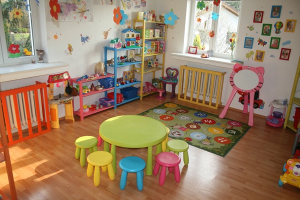kindergarten-interieur-runder-grüner-tisch-und-kleine-bunte-stühle
