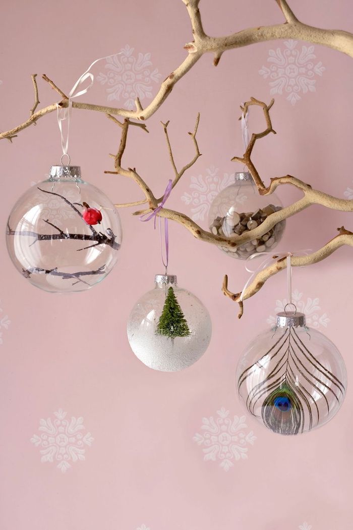 Glaskugeln füllen mit verschiedenen Elementen, Pfauenfeder und Holzstäbchen, kleines rotes Vögelchen und Weihnachtsbaum 