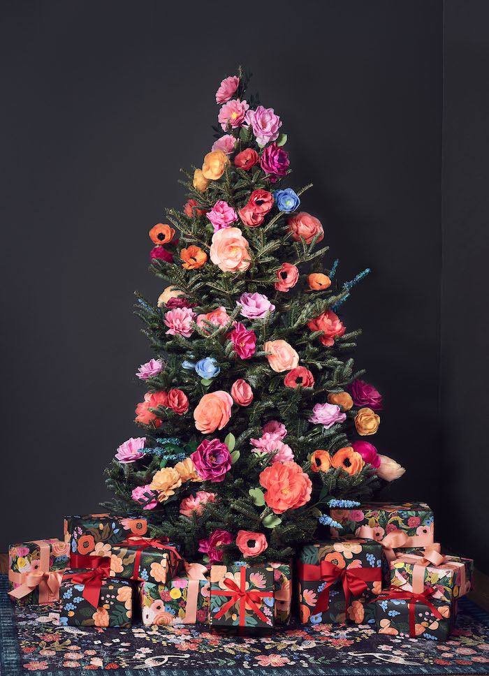 Künstlicher Weihnachtsbaum geschmückt mit bunten Blumen, Geschenkverpackungen mit Blumenmotiven 