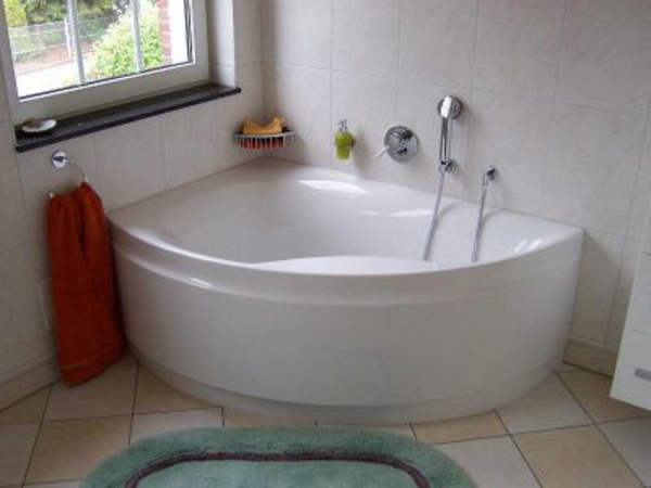 weiße-eckwanne-neben-einem-fenster - einfach ausgestattetes badezimmer