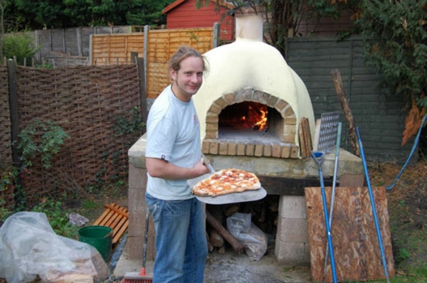 pizzaofen im garten - ein mann macht pizza