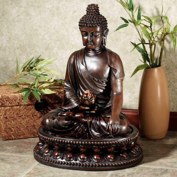 Buddha-Brunnen-eine-vase-mit-einer-grünen-pflanze-daneben