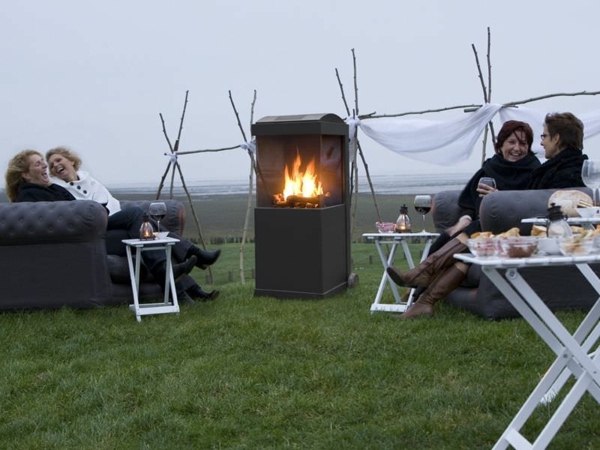 moderner garten mit einem kamin und leuten, die sich entspannen