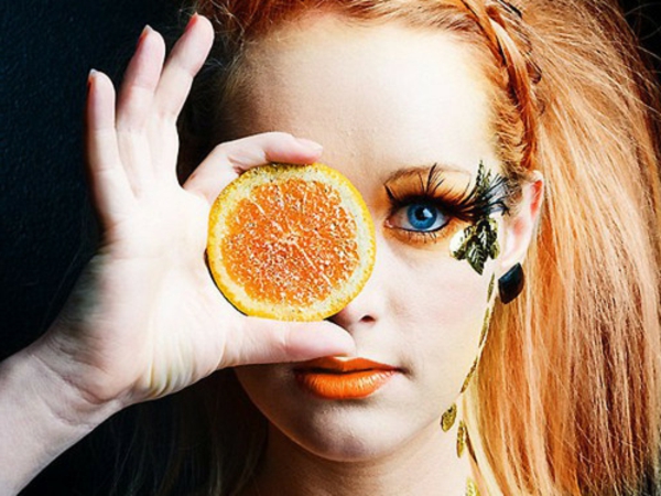 blaue augen schminken - frau mit einer scheibe Orange