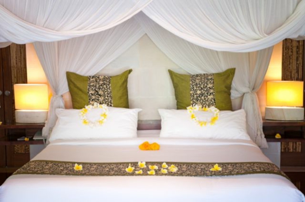 romantisches-schlafzimmer-design-gelbe-blumenblätter-auf-dem-weißen-bett