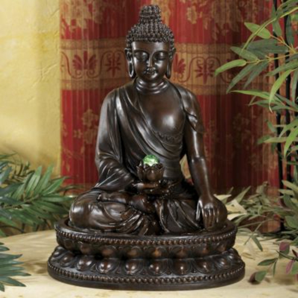 wunderschöner-Buddha-Brunnen-neben-einer-grünen-pflanze