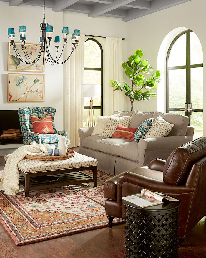 Wohnzimmer einrichten, brauner Ledersessel, weißes Sofa mit bunten Deko Kissen, Kanne und Becher auf Rattankorb, bunter Teppich