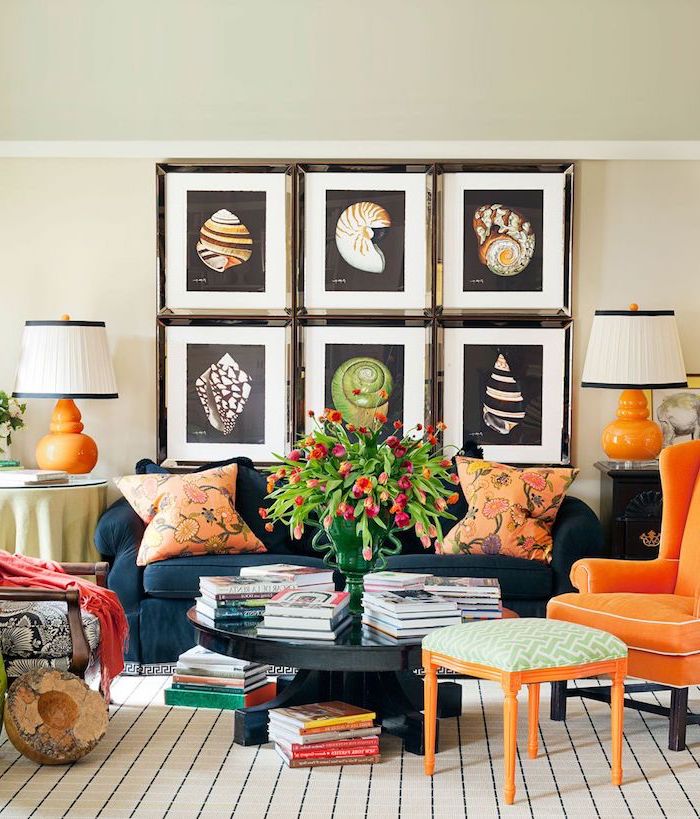 Wohnzimmer Einrichtung in grellen Farben, Muschel Bilder, Sessel und Deko Kissen in Orange, Bücher und Tulpenstrauß in Glasvase 