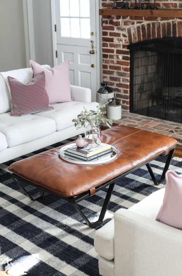 Wohnzimmer in Landhausstil einrichten, Couchtisch mit Lederoberfläche, weißes Sofa mit rosafarbenen Dekokissen 