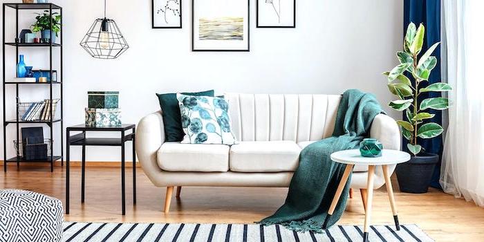 Wohnzimmer minimalistisch einrichten, weißes Sofa mit grünen Deko Kissen und Decke, Regale aus Metall 