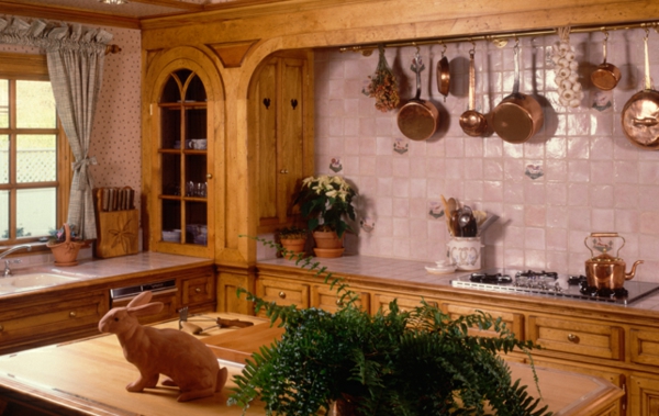 landhaus dekoration - küche mit hängenden pfannen an der wand und einer hase-skulptur