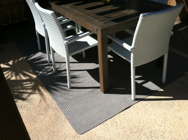 weiße-stühle-massiver-tisch-outdoor-teppich-in-grau