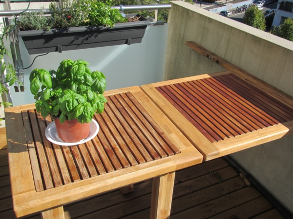 wunderschöner-modern-aussehender-tisch-für-balkon-hölzernes-modell-mit-einer-grünen-pflanze-darauf
