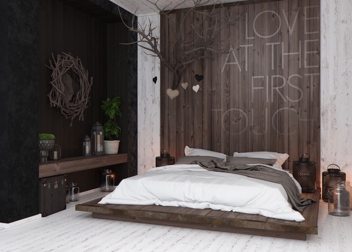 Landhaus Einrichtung im Schlafzimmer, Paletten Bett, weiße Bettwäsche, Holzwand und Boden 