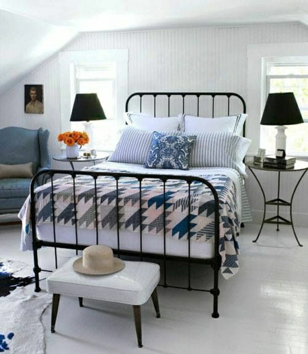 Bett-schwarz-weiß-blau-Sessel-Strohhut-orange-Rosen-weiße-Wände-Tierhaut
