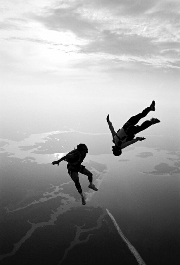 Fallschirm-Springen-zwei-Menschen-Himmel-Erde-Oberfläche-Wolken-schwarz-weiß