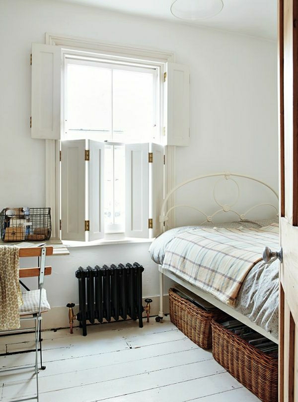 Schlafzimmer-Bett-Fensterläden-weiß-Weidenkörbe-unter-dem-Bett-Heizkörper