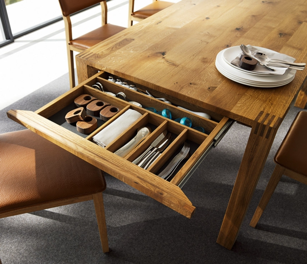 ausziebarer-esstisch-aus-massivholz-mit-einer-schublade - teller auf dem tisch