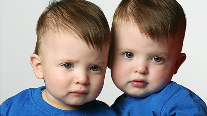 eineiige-zwillinge-kleine-süße-jungen-mit-blauer-kleidung