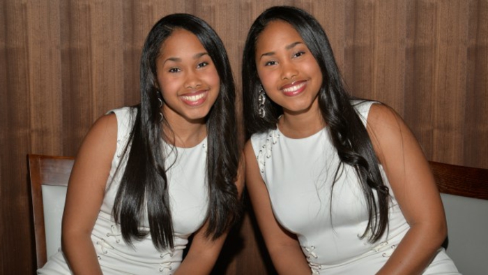 eineiige-zwillinge-zwei-junge-frauen-mit-langen-schwarzen-haaren-und-weißen-kleidern