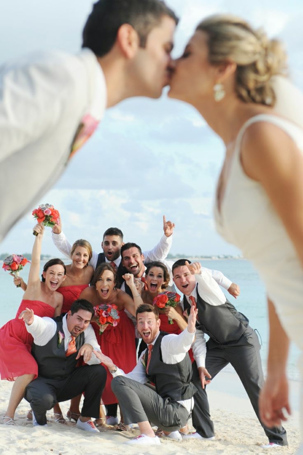 heiraten-am-strand-braut-und-bräutigam-küssen-sich-vor-ihren-freunden