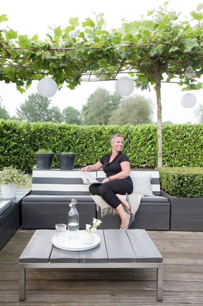terrassenüberdachunggrüne-pflanzen-und-tisch-mit-sofa