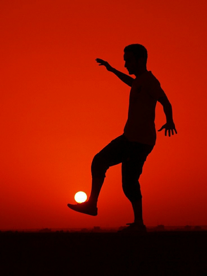 Mann-Fußballer-Sonne-Ball-Sonnenuntergang