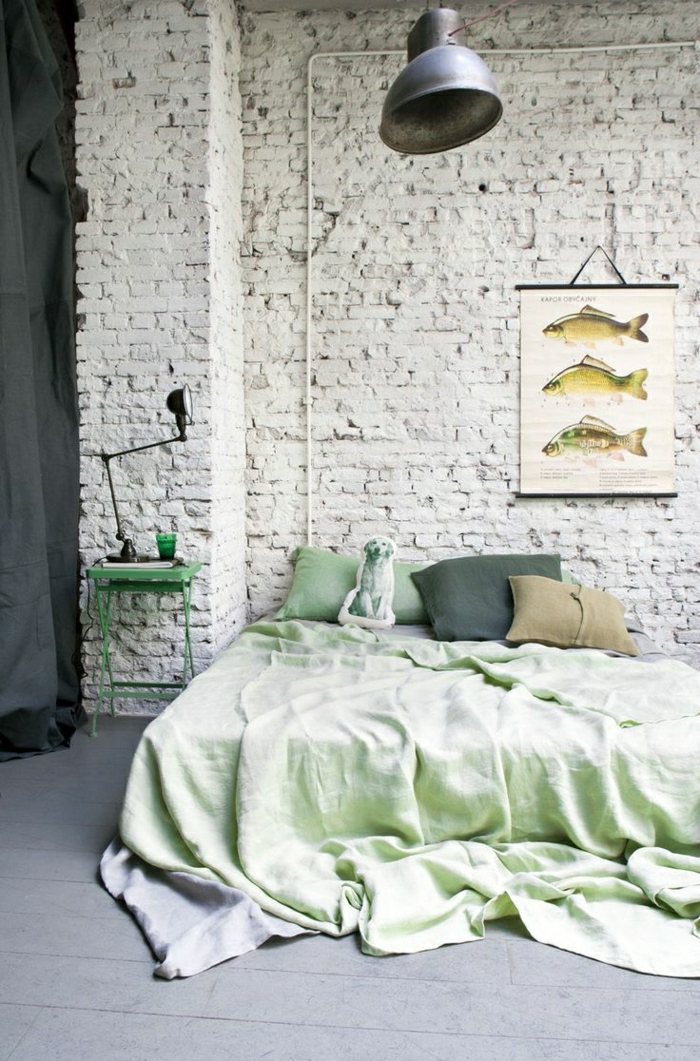 Schlafzimmer-industrielles-Design-Ziegelwände-Fische-Bild-grüner-Nachttisch-schöne-Bettwäsche-Hund-Kisse