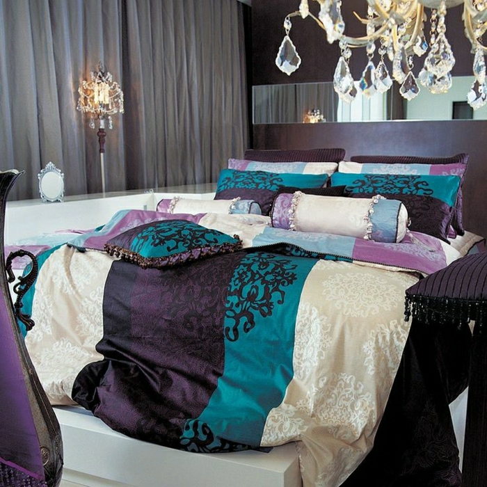 elegantes-Schlafzimmer-Kronleuchter-Kristalle-Bettwäsche-lila-türkisblau-beige-Kissen-Ornamente