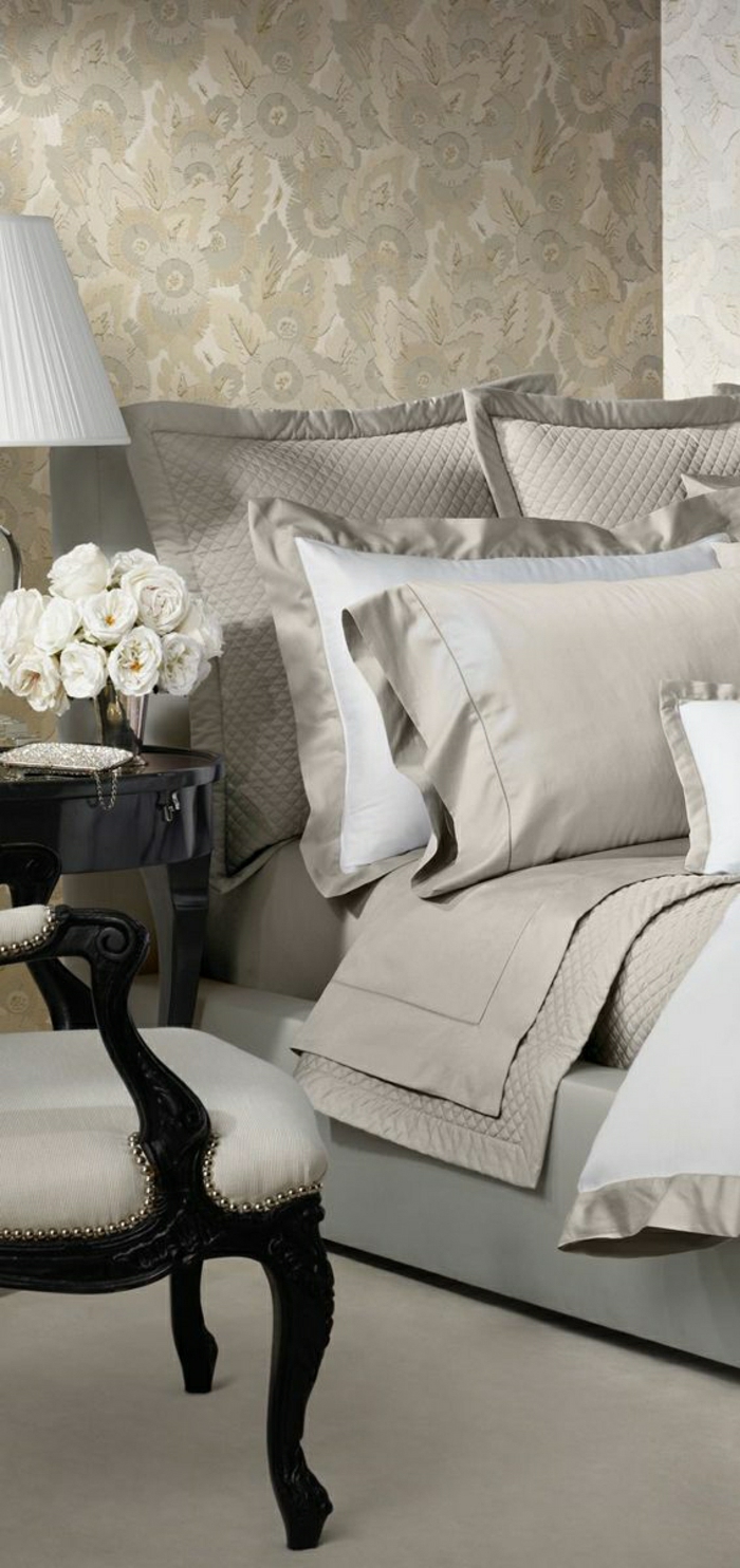 elegantes-Schlafzimmer-schöne-Bettwäsche-beige-Farbe-aristokratischer-Sessel-weiße-Rosen