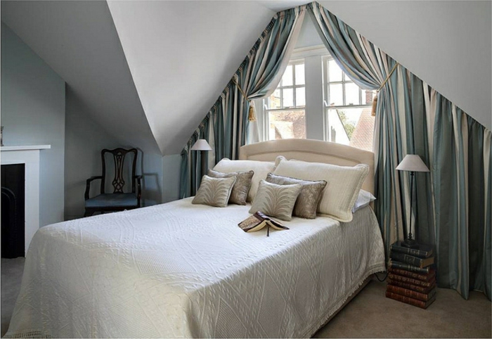 gardinen-für-dreiecksfenster-im-eleganten-schlafzimmer-mit-vielen-dekokissen-auf-dem-bett