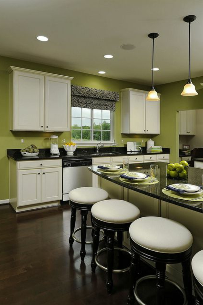 grüne-wandfarbe-elegante-weiße-hocker-in-einer-modernen-küche